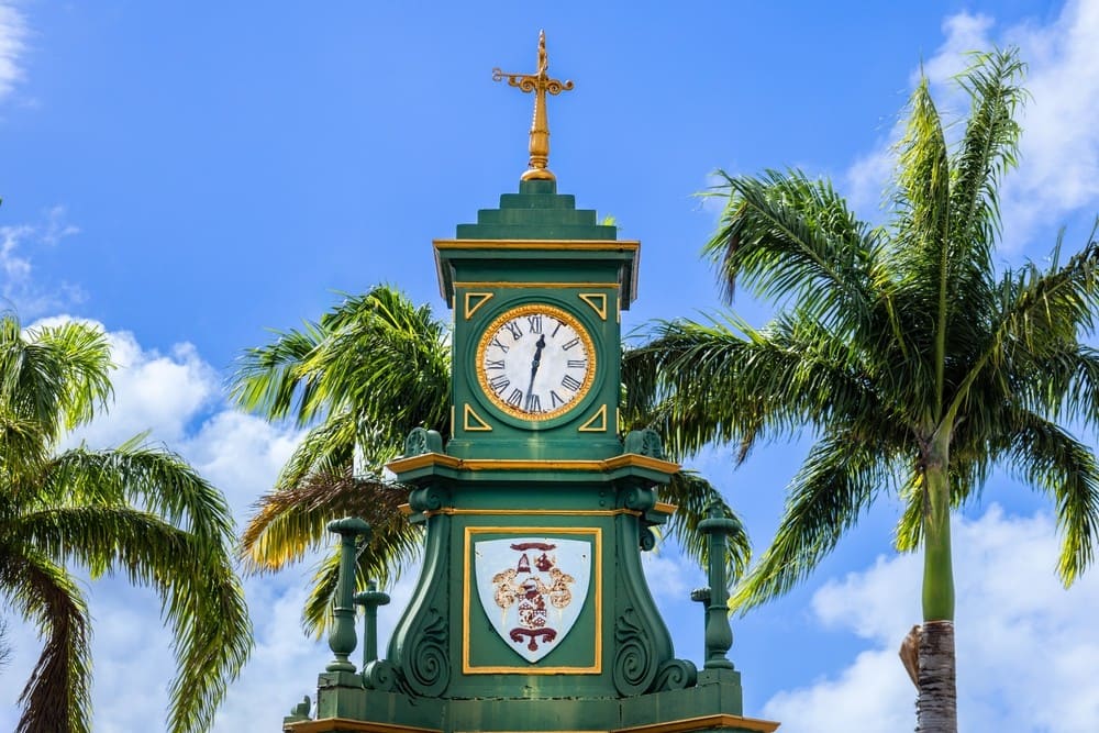 The Berkeley Memorial clock in Basseterre, green and gold against a blue sky