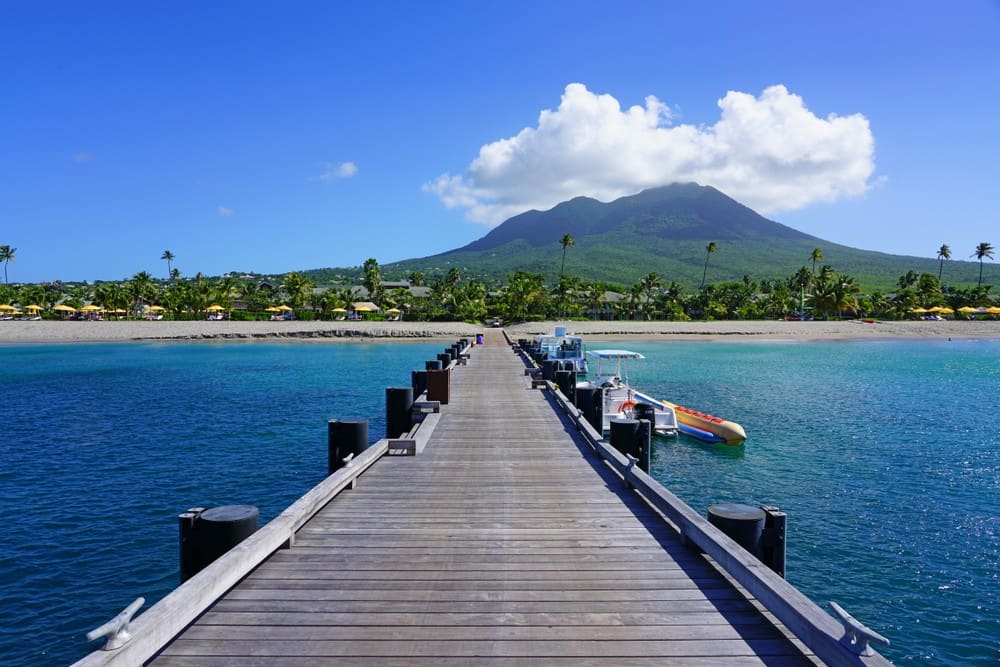 Wooden pier on Pinney's Beach leading to Nevis Peak